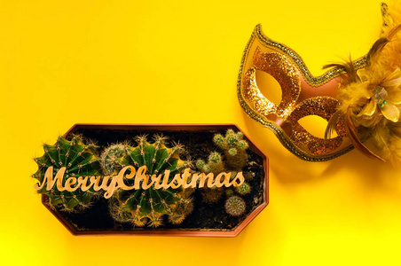 狂欢节面具和小仙人掌使用的邮票圣诞快乐, 在黄色背景, 复制空间, 特写