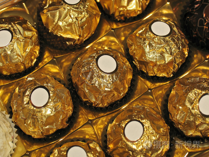 与金色箔和白色小标签文本中的圆形状的巧克力