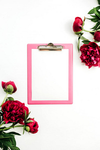 剪贴板在白色背景的粉红色牡丹花框架内模拟。平躺, 顶部视图