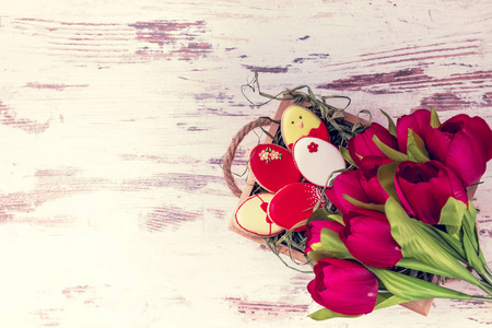复活节姜饼饼干和木桌上美丽的郁金香花束。兔子和鸡蛋。贺卡。从上面看。复制空间