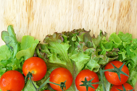 西红柿和生菜上木制的背景图片