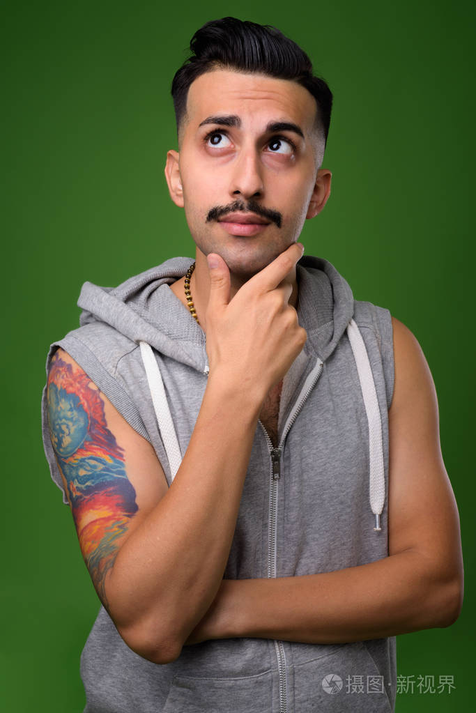 年轻英俊的伊朗男子与胡子对绿色背板