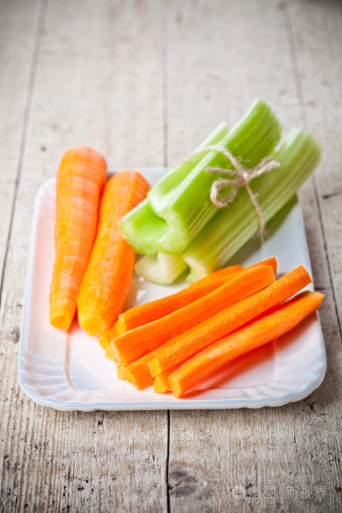 捆绑的新鲜绿色芹菜的茎和胡萝卜