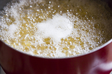 在滚烫的开水和一些油中烹调面食照片