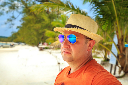 在海滩上放松的太阳镜和帽子的游客