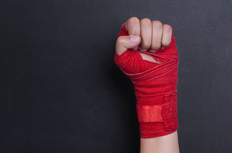 女性手在绷带与红色拳击磁带被上升作为权利斗争的标志。像女孩一样战斗