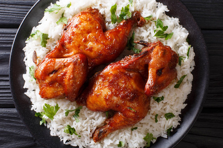 酱油,生姜和蜂蜜烤的辛辣半只鸡, 在桌子上的盘子里放上米饭特写镜头