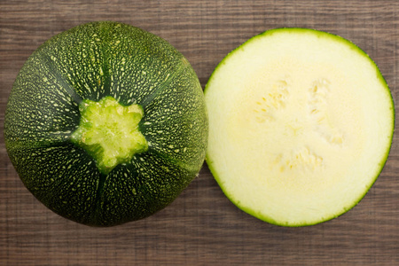 一圆西葫芦与横断面半 flatlay 在褐色木头新鲜的夏天 squas照片