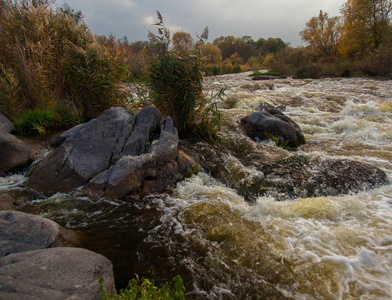 在一个明亮的秋日, 山河的颜色和阴影的游戏在急流周围流动