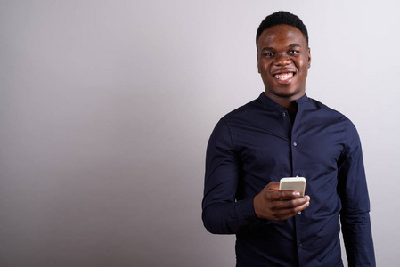 年轻的非洲商人用手机反对白色背影