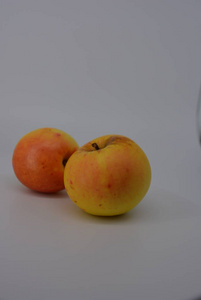 秋季新鲜可口的黄色苹果, 红色的桶和红色的圆点, 白色背景的木头, 新鲜的水果, 新鲜的食物