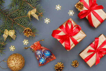 圣诞装饰。礼品盒, 玩具球, 天然冷杉树枝与锥在灰色的背景。顶部视图。圣诞贺卡概念