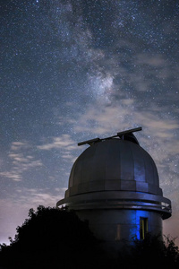 一个小望远镜的圆顶在一个天文台反对银河
