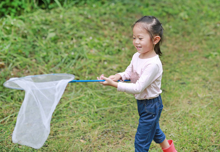 可爱的小亚洲女孩在田间昆虫网夏天
