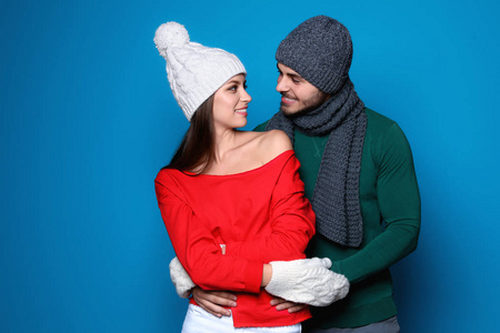 年轻夫妇在温暖的衣服上的颜色背景。圣诞庆典