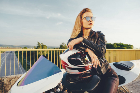 美丽的妇女与太阳镜驾驶摩托车