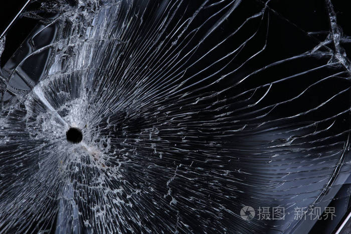 宏观纹理背景碎玻璃与径向裂纹在黑色背景