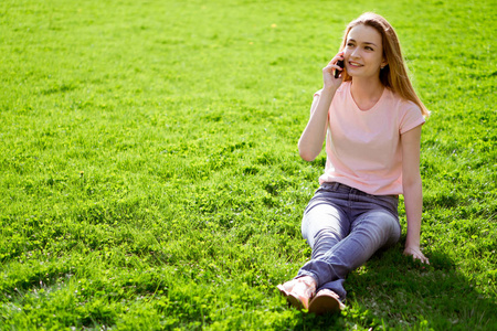 女孩在草坪上说电话