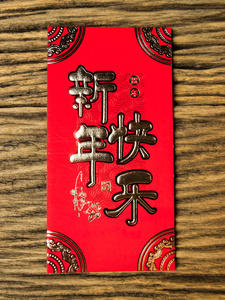红色信封在木背景与2月礼物中国新年。信封上的中文文本, 意思是中国新年快乐