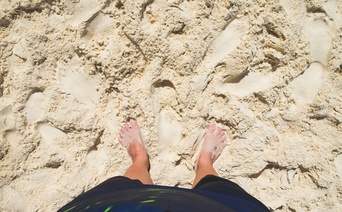 在阳光明媚的日子, 夏日假期的生活方式, 赤脚与衣站在海边沙滩上。在顶部保留空间以添加文本