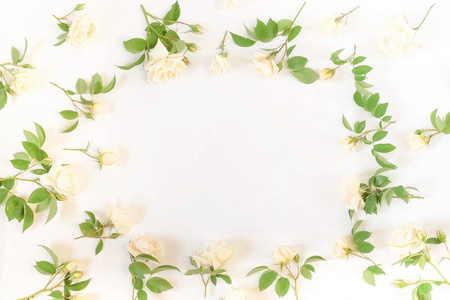 鲜花框架的新鲜玫瑰花蕾和树叶在白色的背景。平躺, 顶部视图样机