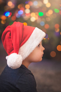 坐在圣诞树前的一个可爱的白人小男孩的肖像