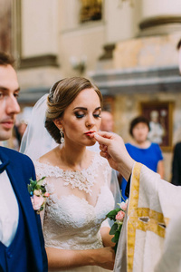 新娘亲吻结婚戒指的垂直照片
