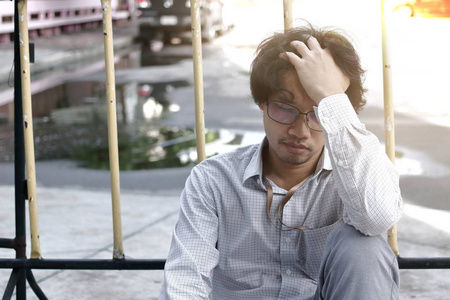 亚洲男士困惑疲惫的亚洲商界男士用手捂脸照片