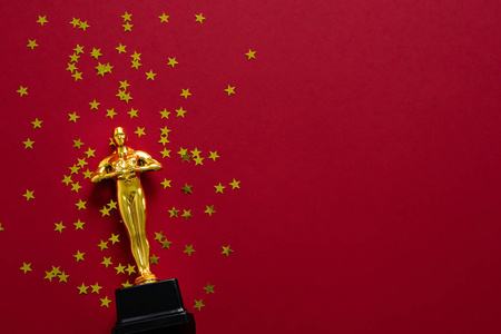 奖杯星金像奖杯与星五彩纸屑在红色背景照片