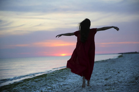 夕阳下海边的女人图片