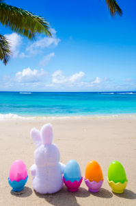 复活节兔子和彩色蛋在海滩上图片