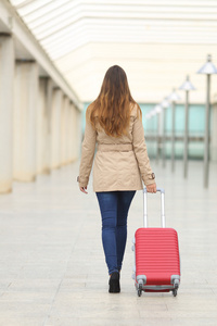 旅游女人走在机场西装便携包