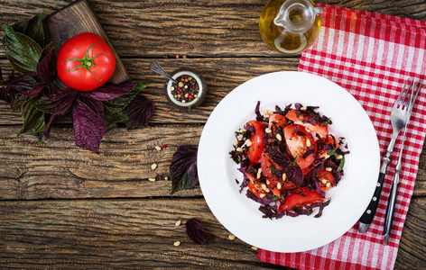 西红柿沙拉, 紫色罗勒和松子。纯素食的食物。意大利餐。顶部视图。平躺