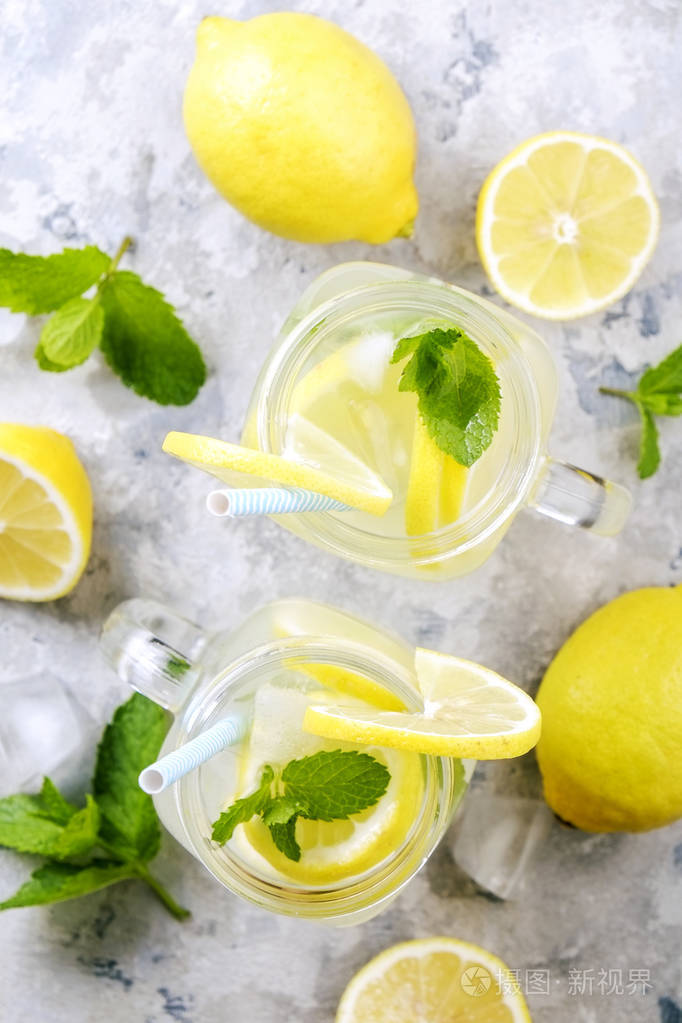 两个梅森瓶眼镜的自制清爽柠檬汁与切片有机成熟柠檬, 整体和减半