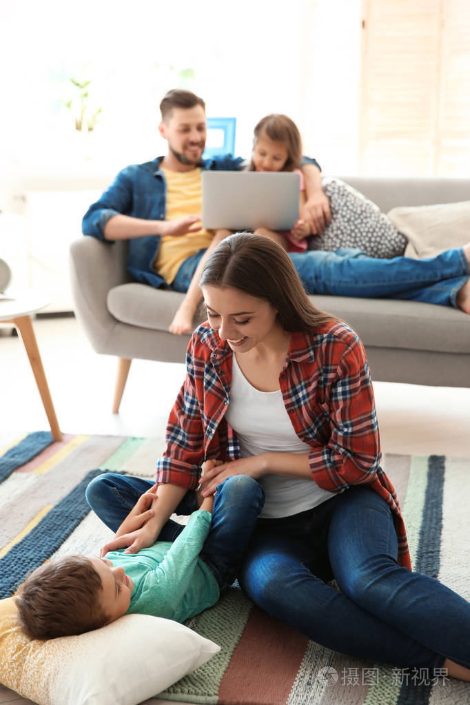 年轻夫妇花时间和孩子们呆在家里.幸福家庭