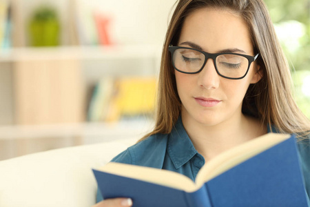 一张戴眼镜的严肃女人在家里看书的正面画像