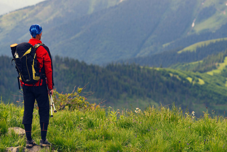探险家站在绿色的山坡上, 欣赏着茂密的山丘伸展到地平线令人敬畏的山上旅行。后退视图