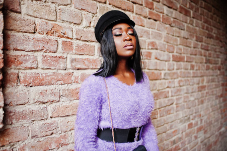 非洲裔美国妇女在紫罗兰色礼服和帽子摆在户外反对砖 tonel