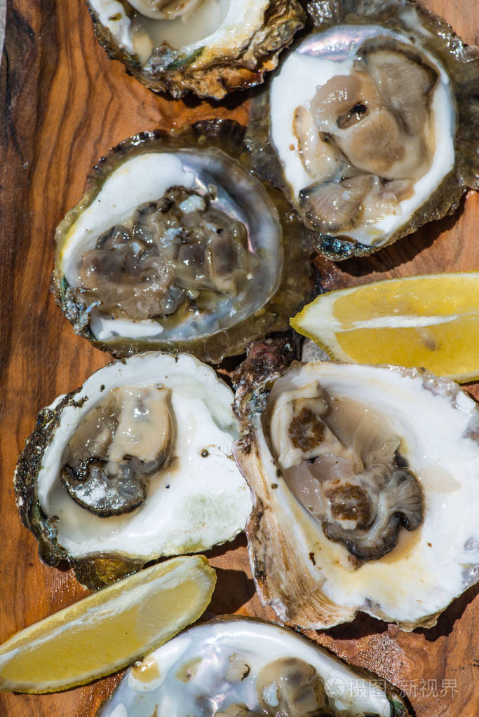 在木盘子里加柠檬的牡蛎男人的春药