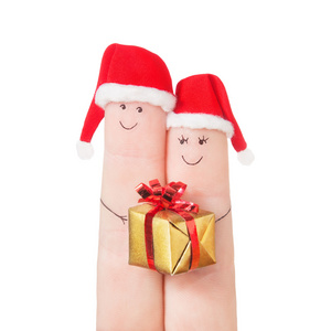 在圣诞的帽子与礼品盒手指脸