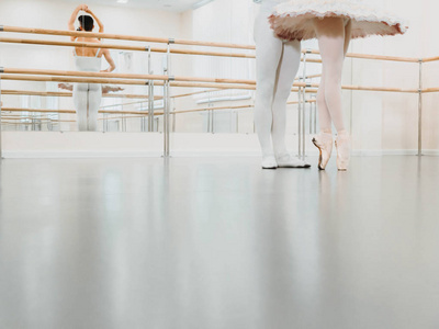 腿闭上了排练在芭蕾大厅或演播室与极简内部。年轻的职业舞者情侣在美丽的服装一起跳舞。复制空间