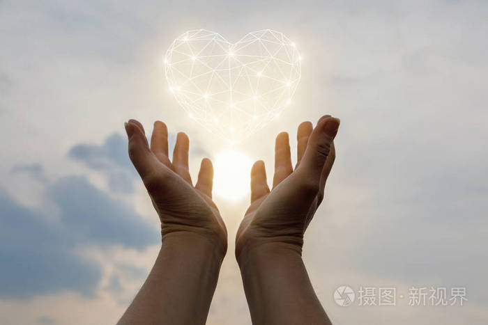 双手支撑着天空中的心符号