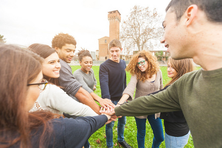 多种族集团的双手插在堆栈中,团队合作的朋友照片