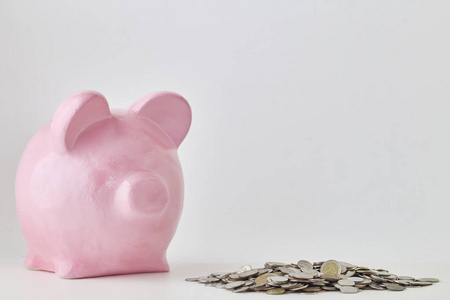 粉红色的小猪银行和硬币在白色背景。金融, 省钱, 在自然状态