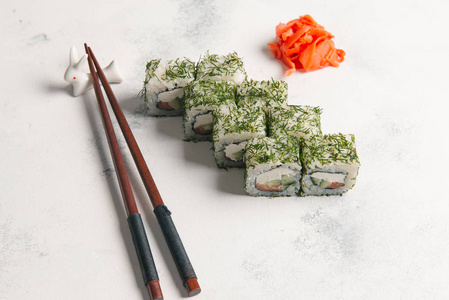 传统日本寿司卷用姜和筷子在石头背景上