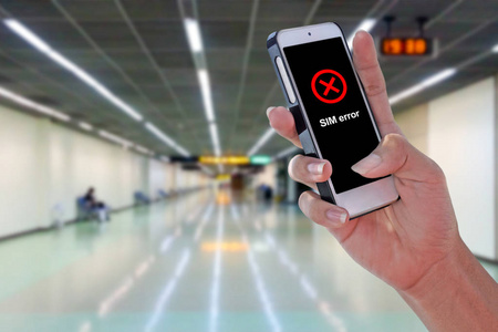 人使用 Sim 错误智能手机在机场和模糊背景与修剪路径在屏幕面板上