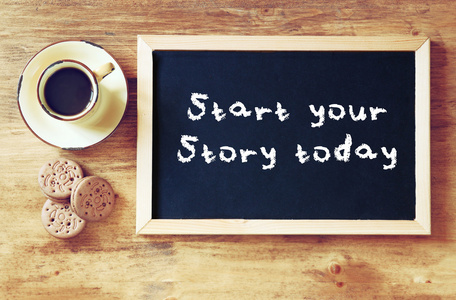 顶视图的黑板上用这句话开始你今天旁边杯黑咖啡和饼干的故事