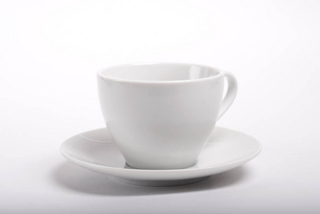 白色背景的碟形空陶咖啡杯照片