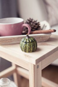 小瓶, 一杯热茶, 秋天的装饰, 一本书, 木椅上的南瓜。舒适的秋色装饰。秋天的内饰, 沙发。秋天。冬天
