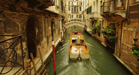 威尼斯狭窄运河的黑暗景象。船在运动中